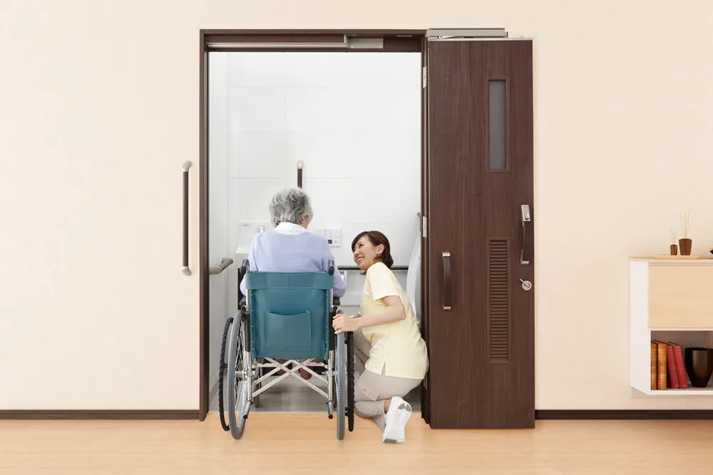 引き戸にも開き戸にもなる新発想のドアで高齢者施設トイレを使いやすくコンパクトに