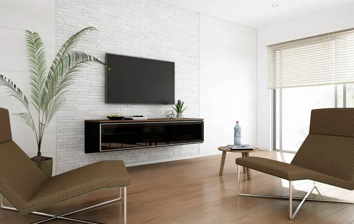 大建工業「MiSEL(ミセル)」のフロートタイプ(宙に浮いた吊り戸棚タイプ)のオーダーテレビ台/TVボード壁面収納の製作例画像。壁面収納はガラスの扉がついており、中にはAV機器を収納できるようになっている。壁には白いタイルがあり、壁掛けテレビが施工されている。手前にはソファが2つ、サイドテーブルが1つある