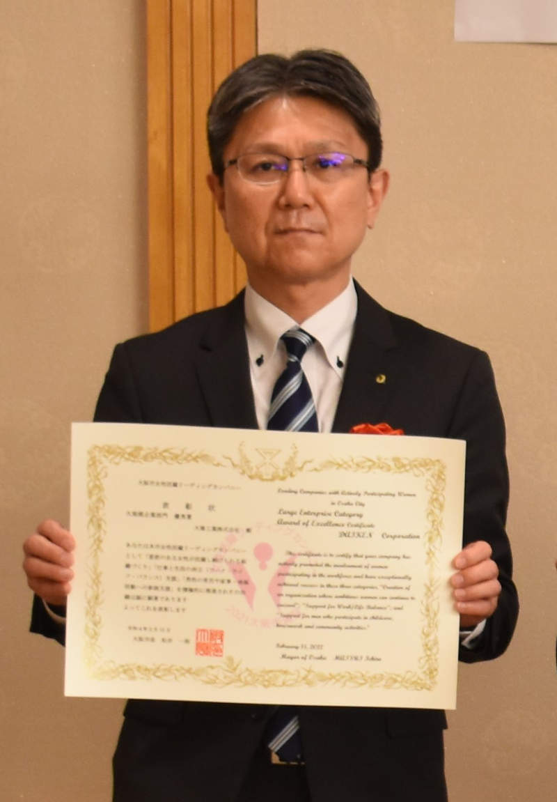 表彰状を持つ総務人事部長 黒田